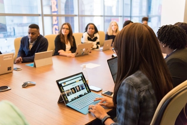 Teamvergadering met HR-professional die personeelsanalyses op laptop bekijkt