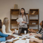 Líder empresarial compartiendo información con miembros del equipo en una reunión